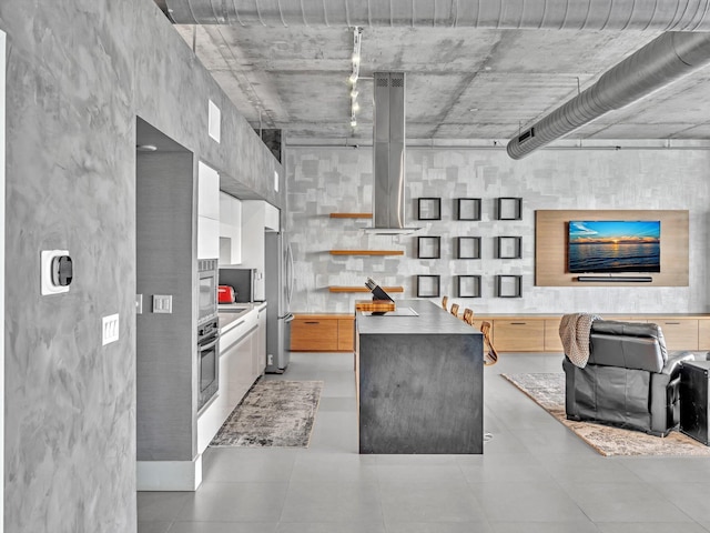 kitchen featuring island range hood, stainless steel appliances, light countertops, a center island, and modern cabinets