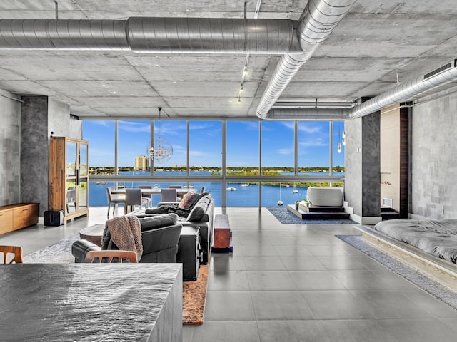 interior space with a water view, a wealth of natural light, and floor to ceiling windows