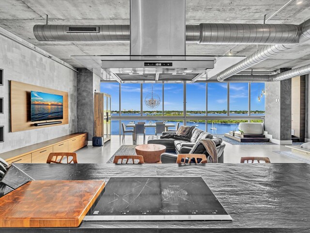 living room with a water view, expansive windows, and visible vents