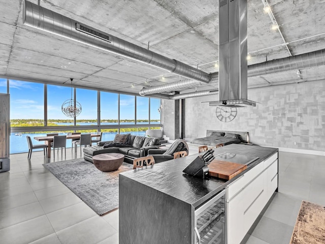 kitchen featuring beverage cooler, a water view, a kitchen island, white cabinetry, and modern cabinets