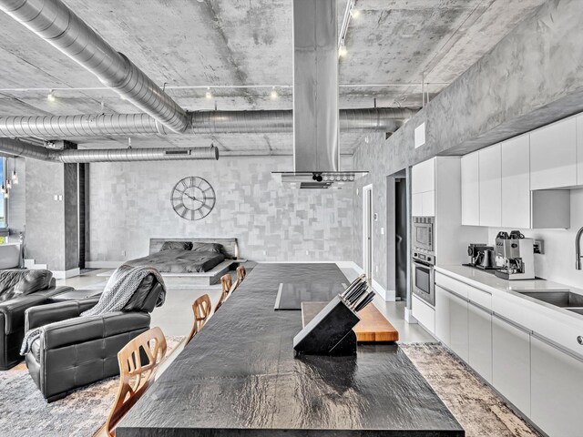 kitchen with appliances with stainless steel finishes, white cabinets, a sink, modern cabinets, and dark stone counters