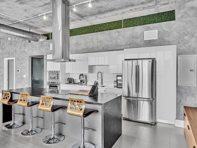 kitchen featuring stainless steel appliances, a breakfast bar, white cabinets, a center island, and modern cabinets