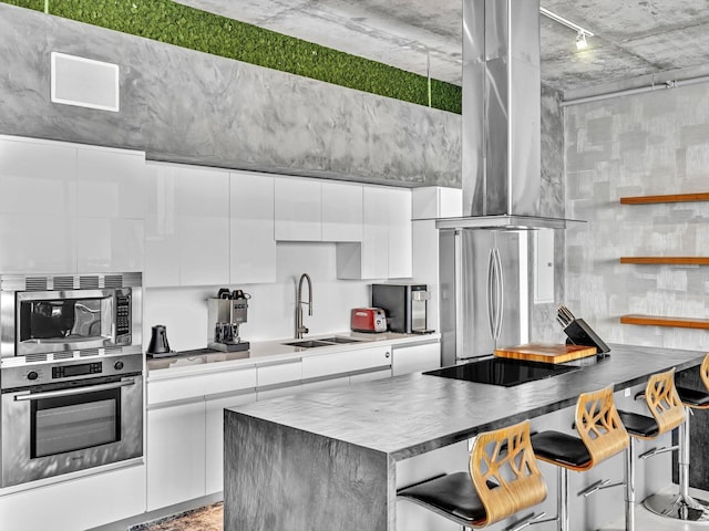 kitchen featuring stainless steel appliances, white cabinetry, a kitchen breakfast bar, ventilation hood, and modern cabinets