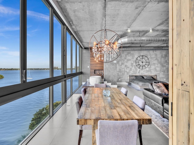 unfurnished dining area with a wall of windows, a water view, and an inviting chandelier