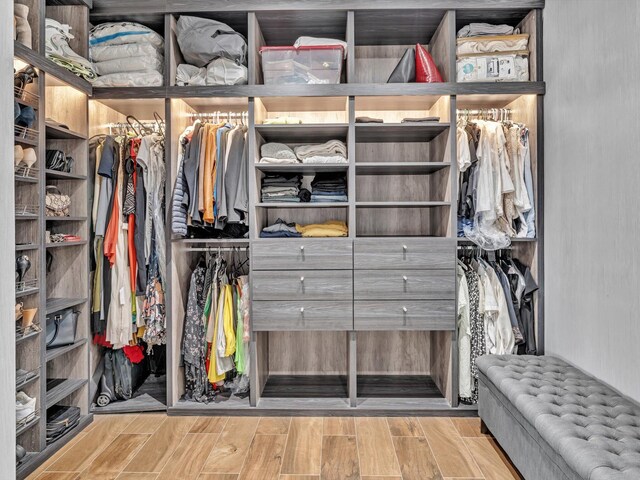 walk in closet with light wood-type flooring