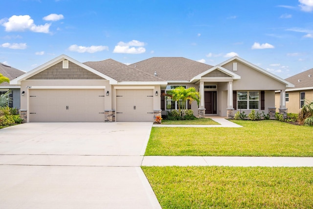 8741 Waterstone Blvd, Fort Pierce, FL 34951 - craftsman-style home with stone siding, an attached garage, a front lawn, and concrete driveway