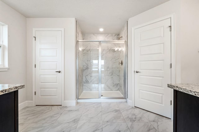 bathroom featuring a textured ceiling, vanity, and a shower with door