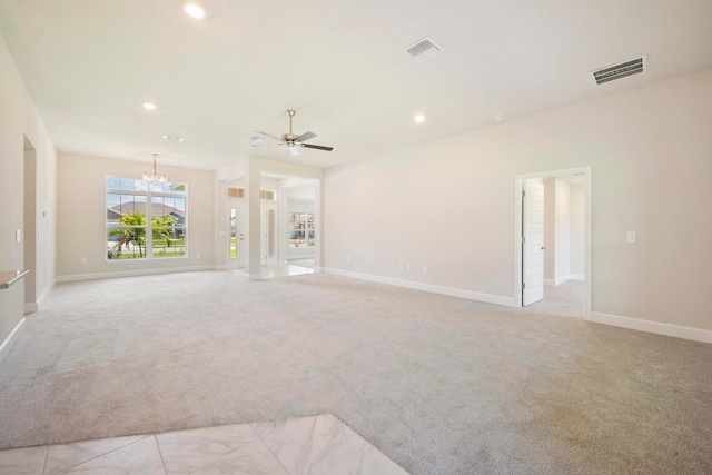 unfurnished living room featuring ceiling fan with notable chandelier and light colored carpet