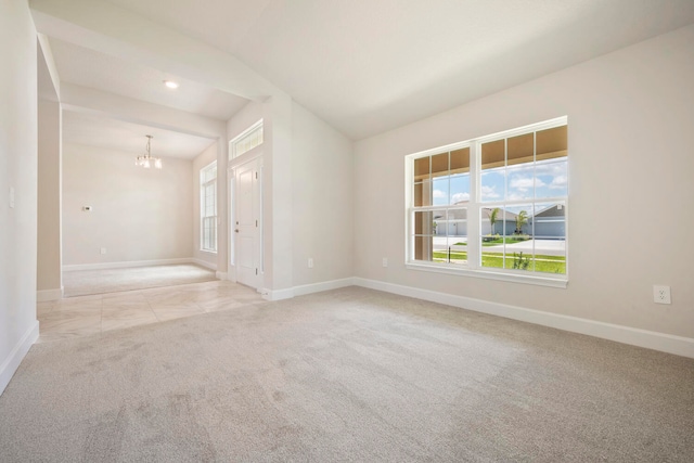 carpeted spare room with a notable chandelier and lofted ceiling