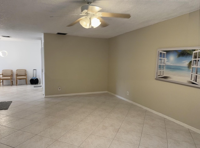 spare room with baseboards, visible vents, ceiling fan, a textured ceiling, and light tile patterned flooring