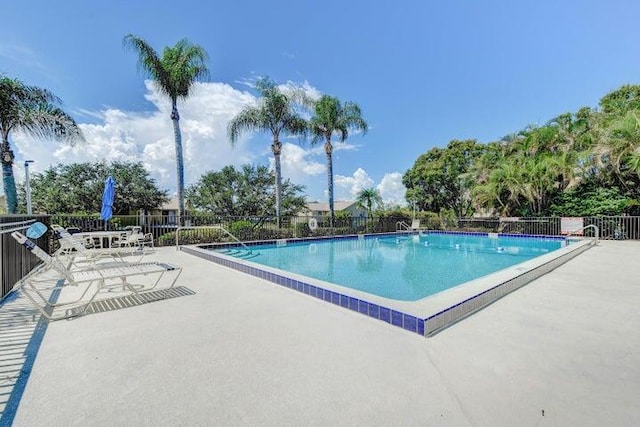 community pool with fence and a patio