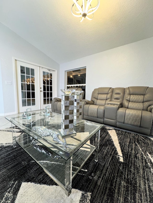 living room featuring a textured ceiling, lofted ceiling, an inviting chandelier, and french doors