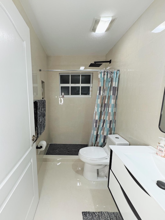 bathroom featuring tile patterned flooring, a shower with curtain, vanity, and toilet