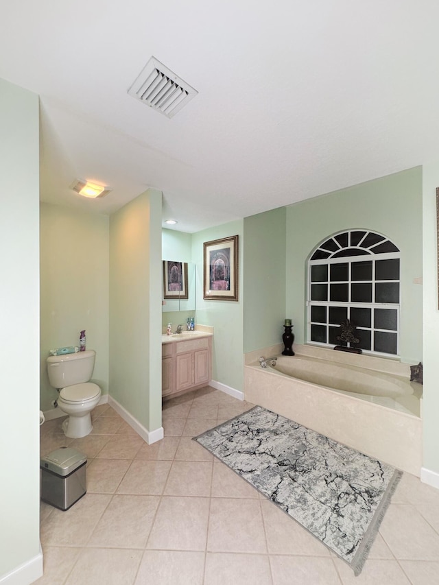 bathroom featuring tile patterned flooring, a washtub, vanity, and toilet