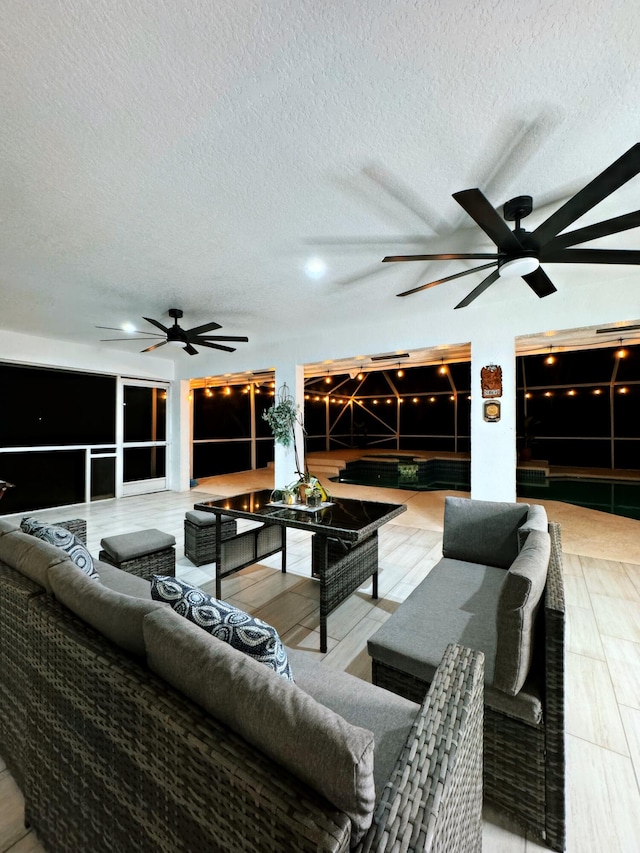 living room featuring ceiling fan and a textured ceiling