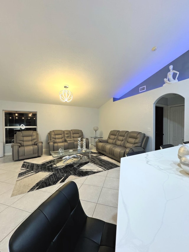 tiled living room featuring vaulted ceiling