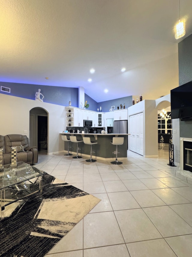 tiled living room with high vaulted ceiling