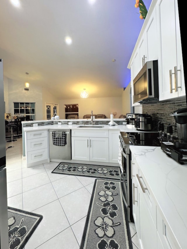 kitchen with sink, stainless steel appliances, light tile patterned flooring, and tasteful backsplash