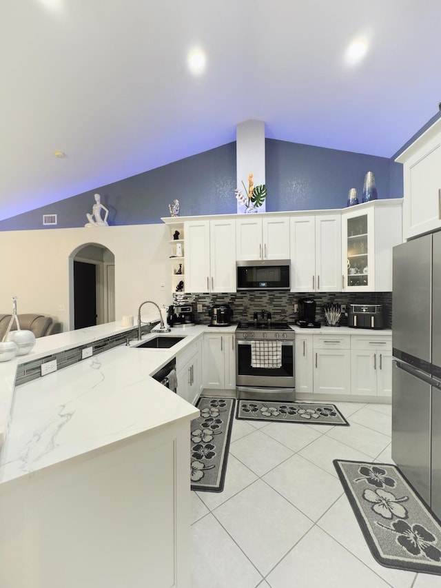 kitchen featuring decorative backsplash, light stone countertops, sink, kitchen peninsula, and stainless steel appliances