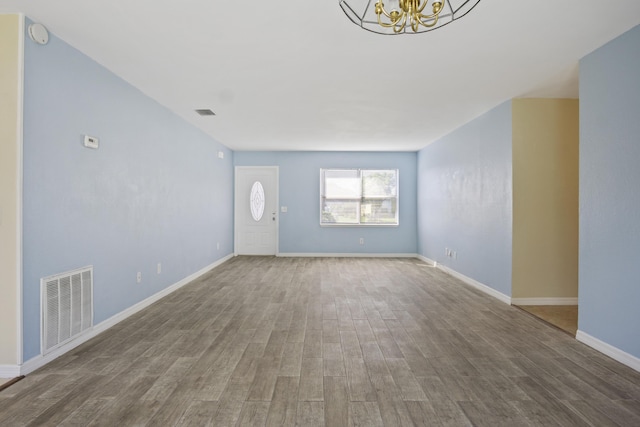 unfurnished living room featuring hardwood / wood-style floors and a notable chandelier