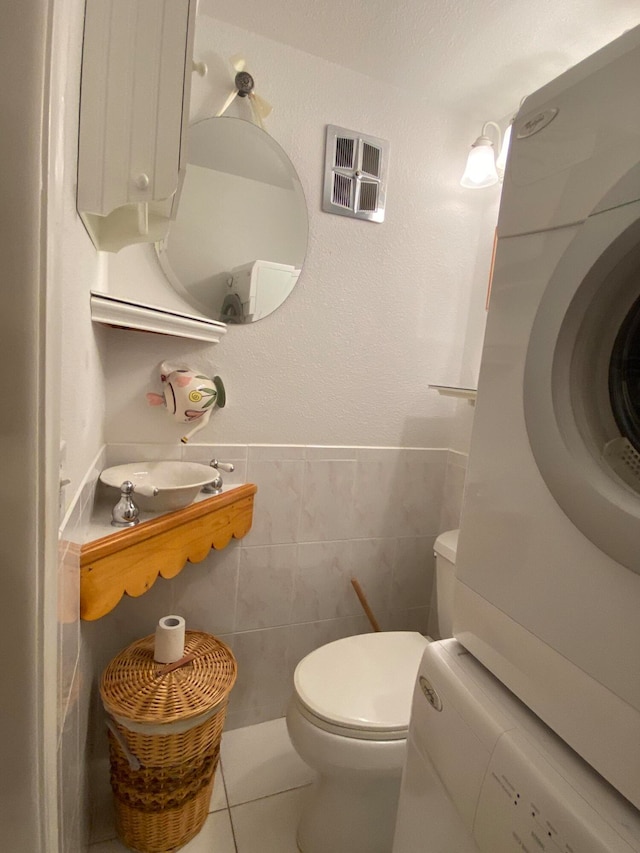 bathroom with tile walls, tile patterned floors, and toilet