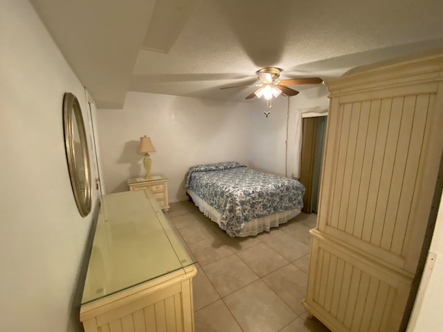 tiled bedroom with ceiling fan and fridge