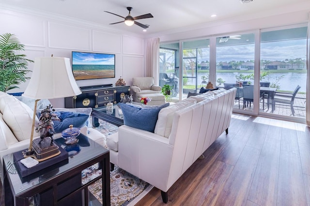 living room featuring ceiling fan, crown molding, and dark wood-type flooring