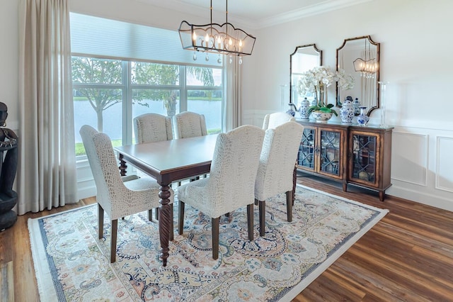 dining area with a notable chandelier, crown molding, and dark hardwood / wood-style floors