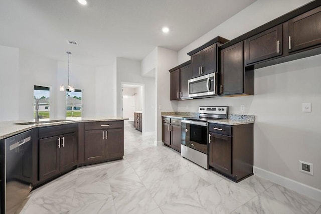 kitchen with sink, dark brown cabinetry, hanging light fixtures, and appliances with stainless steel finishes