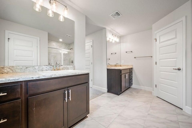 bathroom featuring a shower with door and vanity