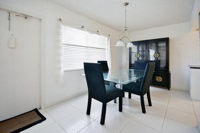 dining room with a textured ceiling and light tile patterned floors