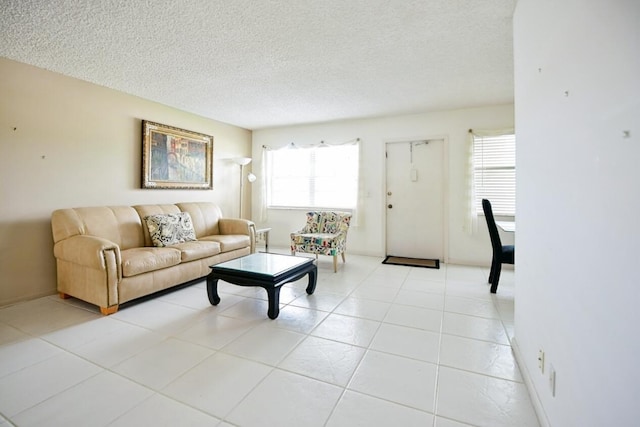 living room featuring a wealth of natural light, light tile patterned flooring, and a textured ceiling