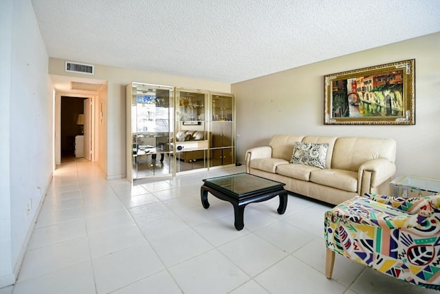 living room with a textured ceiling and light tile patterned flooring