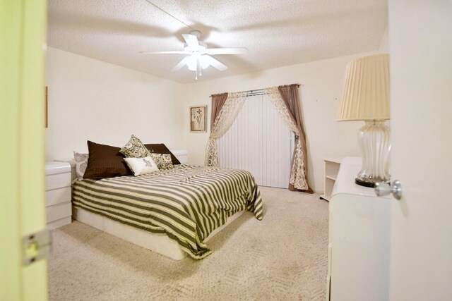 bedroom with ceiling fan, a textured ceiling, and carpet floors