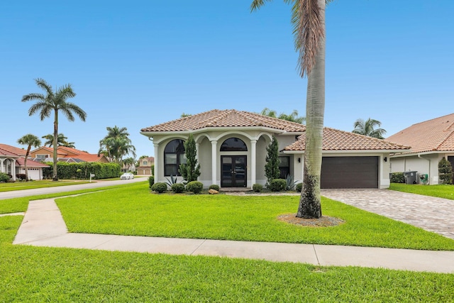 mediterranean / spanish-style house featuring french doors, a tile roof, stucco siding, a garage, and a front lawn