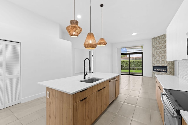 kitchen featuring white cabinets, sink, a center island with sink, and light tile patterned floors