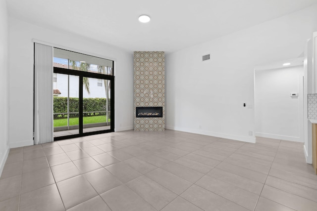 unfurnished living room with light tile patterned floors and a tile fireplace