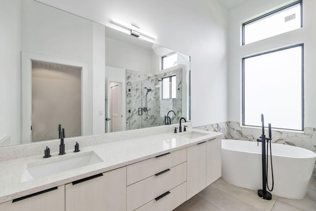 bathroom with shower with separate bathtub, double sink vanity, and tile patterned floors