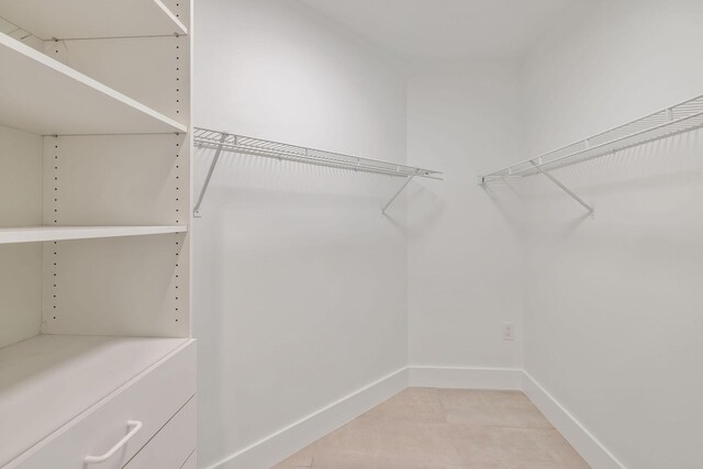 spacious closet with light tile patterned floors