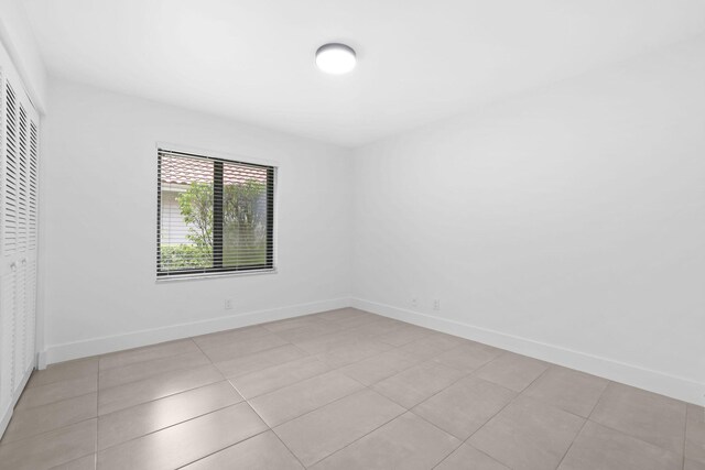 unfurnished bedroom with a closet and light tile patterned floors