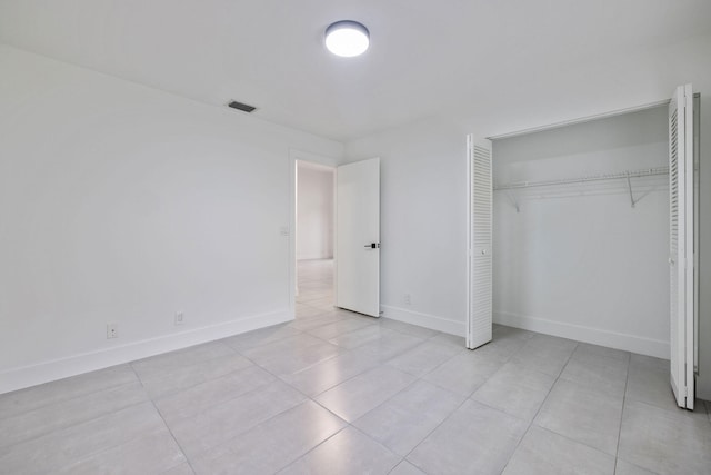 unfurnished bedroom featuring light tile patterned floors and a closet