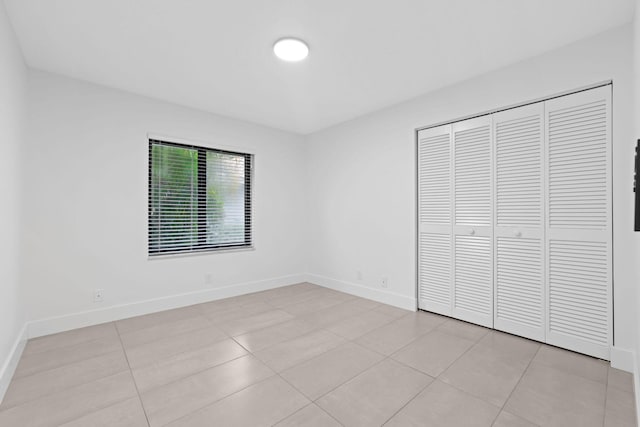 unfurnished bedroom featuring light tile patterned floors and a closet