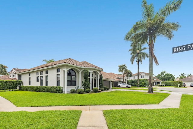 mediterranean / spanish-style home with a garage, concrete driveway, a tile roof, a front yard, and stucco siding