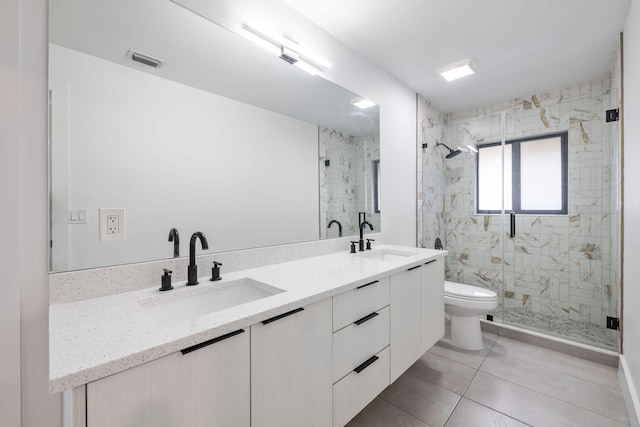 bathroom with tile patterned floors, double sink vanity, walk in shower, and toilet