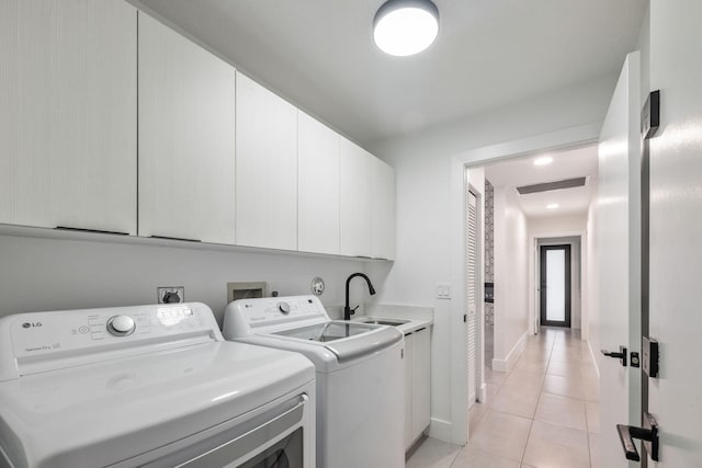 washroom featuring sink, cabinets, light tile patterned flooring, and separate washer and dryer