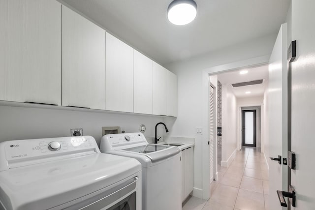 washroom with cabinet space, light tile patterned floors, visible vents, washer and clothes dryer, and a sink