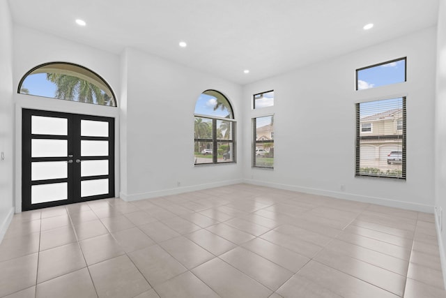 entrance foyer with french doors, a healthy amount of sunlight, and light tile patterned floors