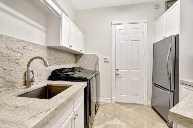 interior space featuring sink, separate washer and dryer, and light tile patterned floors