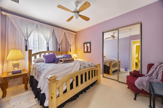 bedroom with a closet, ceiling fan, and a textured ceiling