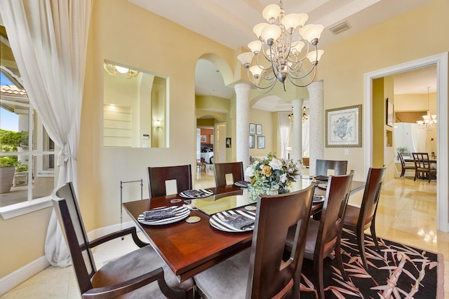 tiled dining room featuring a chandelier and decorative columns